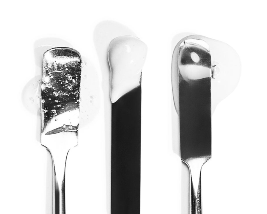 Three metal spatulas with product on the tips.
