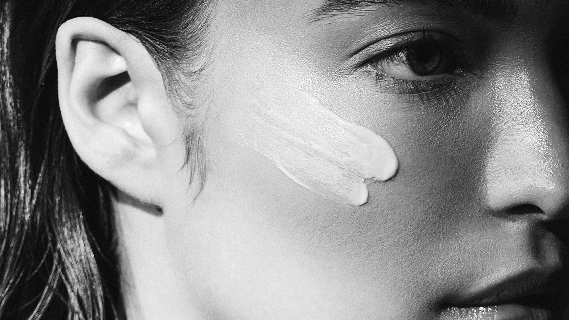 Close-up of a person's face with a mask smears on their cheek