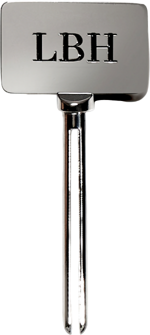 Metallic tube key with LBH initials